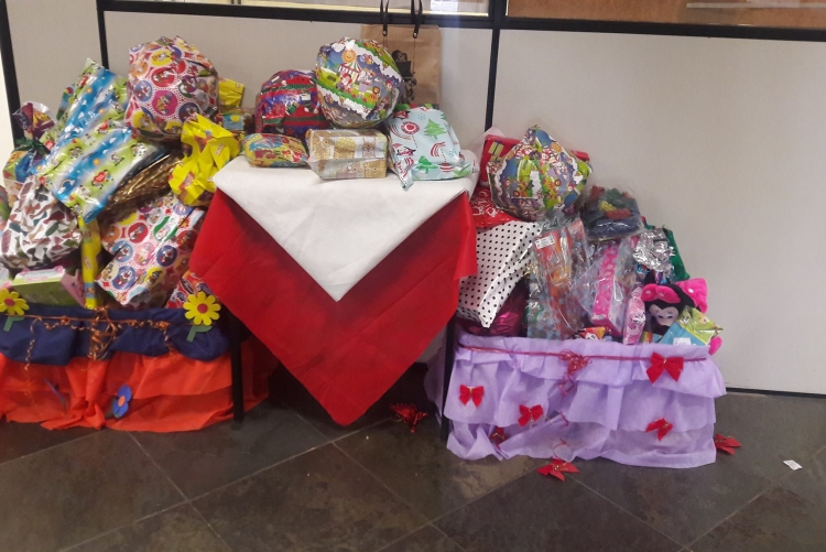 Caixas decoradas contendo embrulhos com presentes para crianças. 