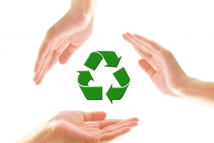 Mãos de pessoas envolvendo o símbolo da reciclagem