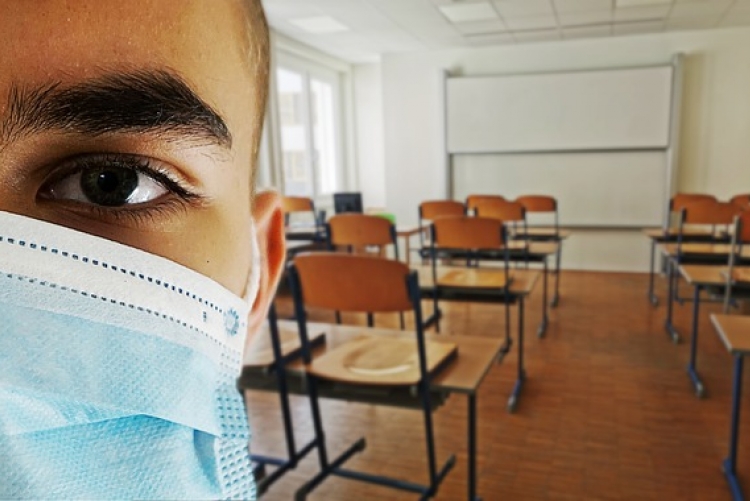 aluno de máscara em sala de aula