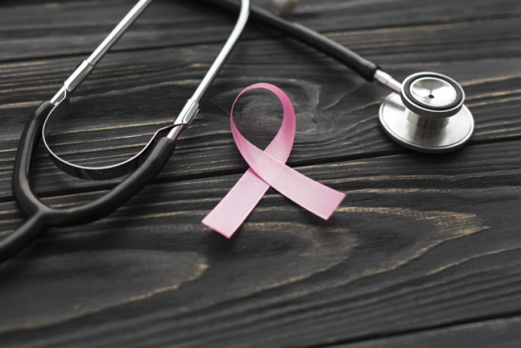 Imagem: estetoscópio e fita rosa em cima de uma mesa