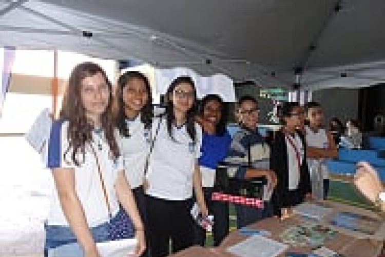 Alunos tirando dúvidas no estande da UFF com a  Bibliotecária Zilma de Jesus e os alunos do Curo