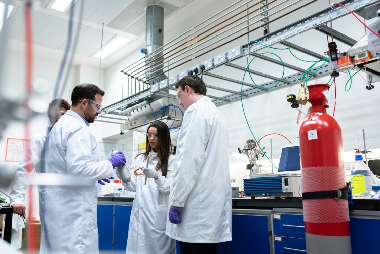 Cientistas de jaleco interagem em um laboratório médico