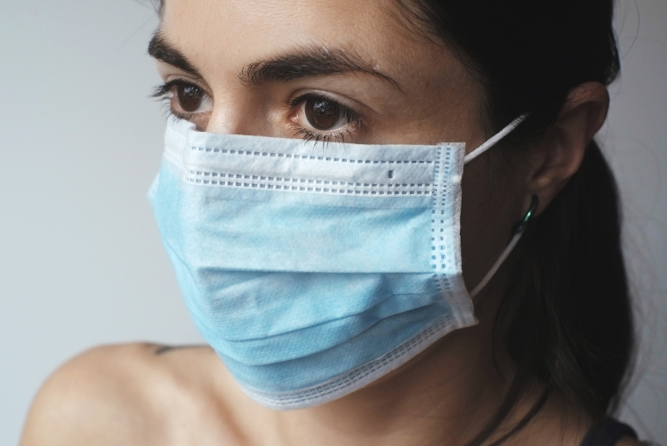 mulher branca, olhos pretos, cabelos pretos usando máscara