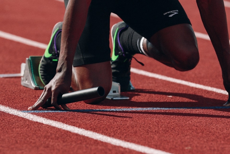Atleta iniciando corrida em pista de atletismo