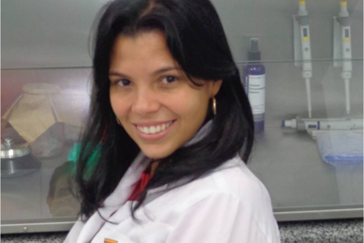 foto de mulher de cabelo preto, liso, vestindo jaleco branco em um laboratório