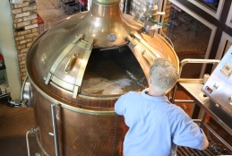 Tonel de cerveja aberto sendo manipulado por um senhor que está de costas