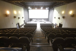 Centro de Artes UFF visto da plateia, com a imagem das fileiras de cadeiras e a tela ao fundo