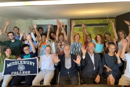 Reitor e vice-reitor reunidos com equipe integrante do projeto de mobilidade. Alguns estão sentados e outros estão em pé. Todos estão com as duas mãos levantadas pra cima.