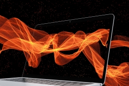 Imagem de uma tela de um laptop sendo atravessadas por ondas luminosas alaranjadas