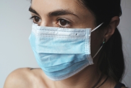 mulher branca, olhos pretos, cabelos pretos usando máscara
