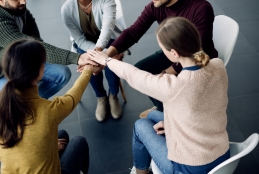 participantes-da-terapia-de-grupo-reunindo-as-maos-em-unidade-durante-uma-sessao-no-centro-medico