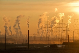 Torres elétricas e grandes chaminés de fábrica exalando fumaça