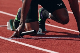 Atleta iniciando corrida em pista de atletismo
