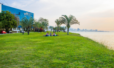 Foto do campus do Gragoatá, com um dos blocos ao fundo e na lateral esquerda a Baía de Guanabara