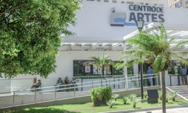 foto do Centro de Artes. Prédio branco, cercado de vegetação verde