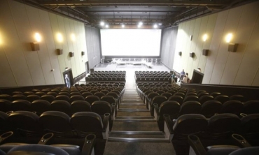 Centro de Artes UFF visto da plateia, com a imagem das fileiras de cadeiras e a tela ao fundo