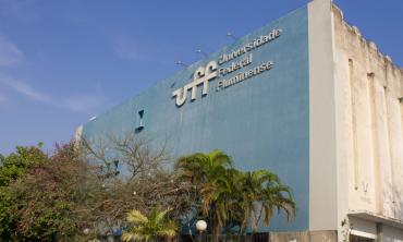 Na foto, prédio na cor azul e cinza de um dos blocos do campus do Gragoatá com o letreiro Universidade Federal Fluminense na cor cinza. 