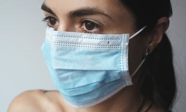 mulher branca, olhos pretos, cabelos pretos usando máscara